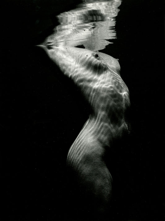 Unframed print 'Underwater Nude' 1980 by Brett Weston: A nude woman figure underwater creates a dramatic black & white abstract composition. 