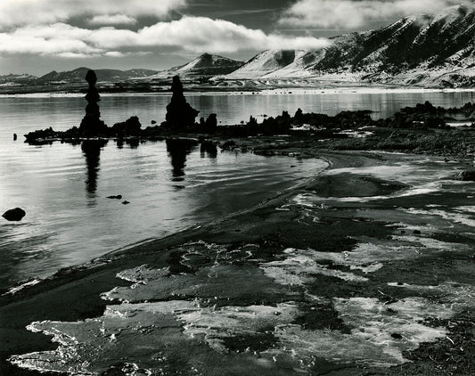 Immerse yourself in the breathtaking beauty of 'Mono Lake California' by Brett Weston. This unframed black and white print captures the vast expanse of the lake's shore and majestic mountains, inviting you to experience the tranquillity of California's natural wonders.