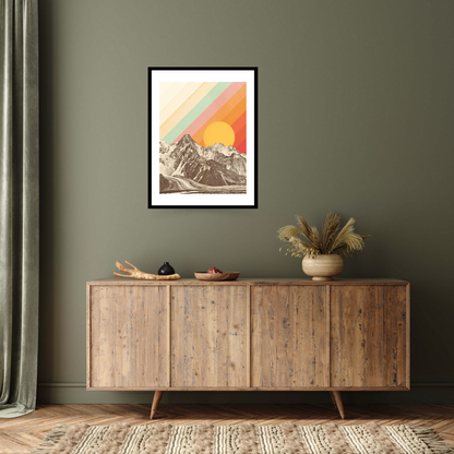 Black framed archival print with a graphic design feel, featuring a stark mountain range under a large sun, overlaid with colourful diagonal stripes in pastel orange, yellow, and green.
