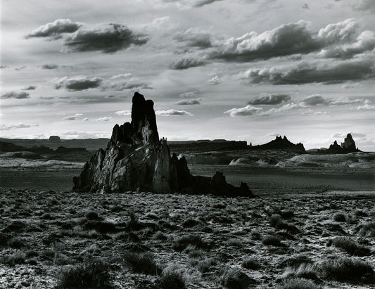 Unframed print 'Rock Formation Desert Landscape' by Brett Weston: A stunning and dramatic black & white photograph of a desert landscape with a cloudy sky.