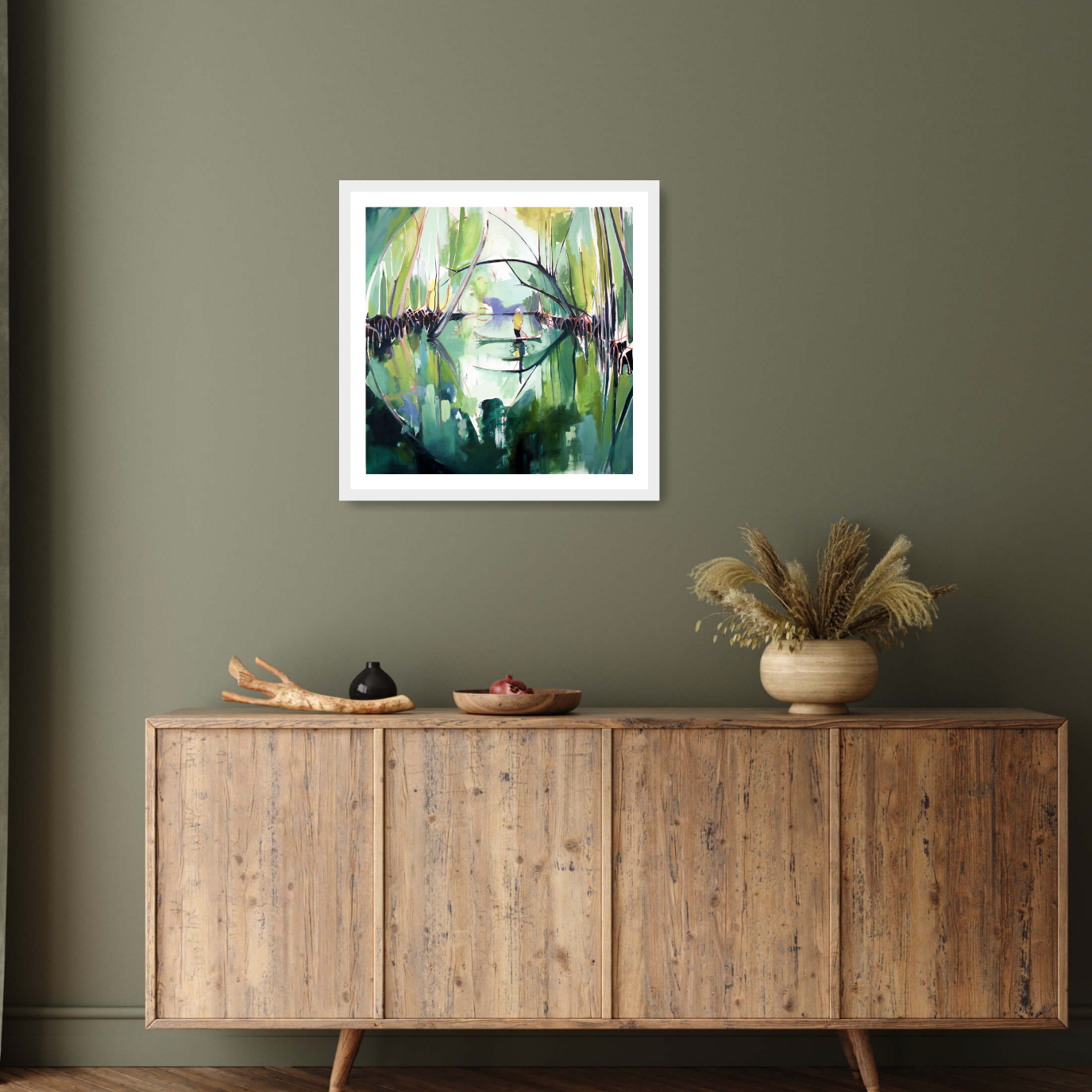 Set in an elegant interior the white framed print ‘Reflected’ by Charlotte Evans: A vibrant contemporary landscape where the multicoloured hues of mangroves are beautifully reflected in the tranquil waters